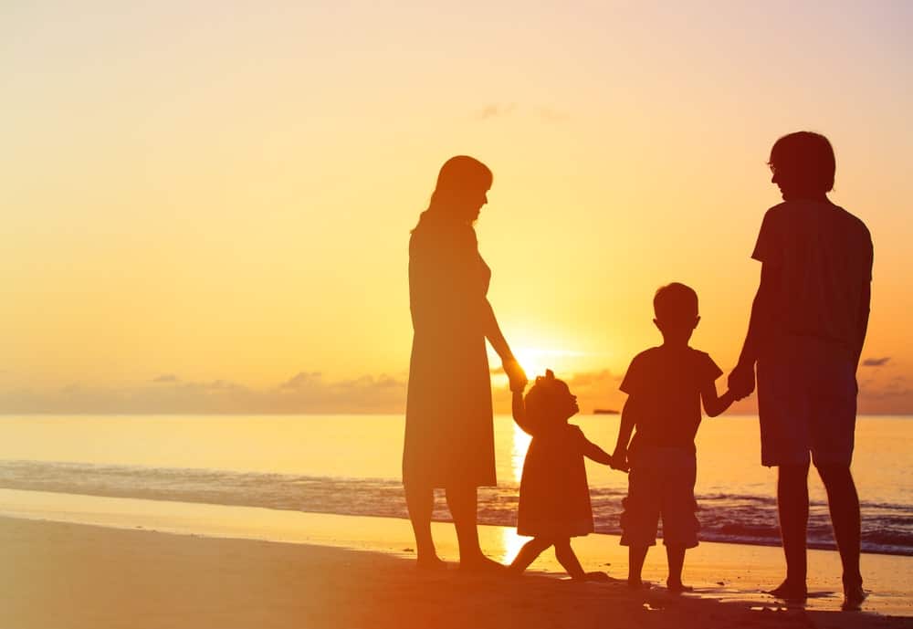 Family & Living Trust for Topeka Kansas Residence portrayed by a family holiday hands on a beach during a sunset.